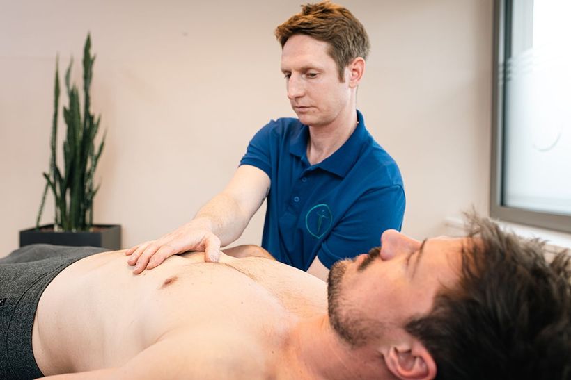 Therapeut für Alternative Heilmethoden der Johannesbad Ambulante Reha behandelt Bauch eines Patienten